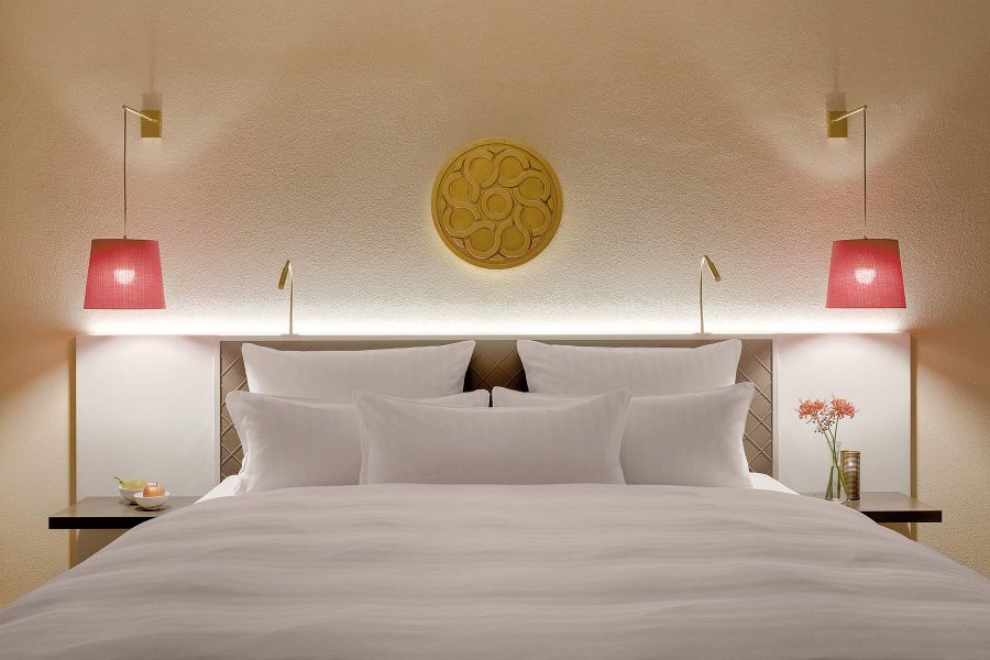 Doppelbett mit dekorativen Lampen und Emblem überm Bett 